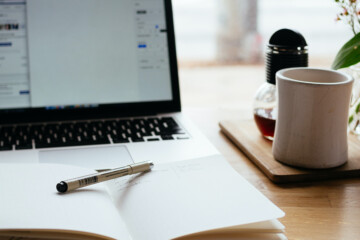 notebook in front of a laptop on a table