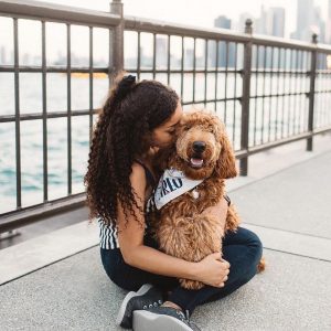 Woman sitting with dog on a dock