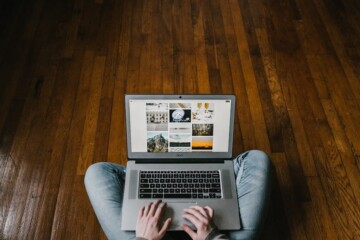 Girl sitting on the floor with a computer looking at stock photos