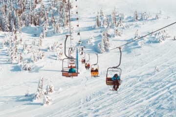 Ski lift on snowy mountain with trees