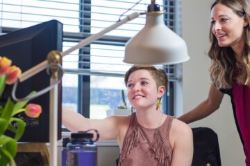 two people talking at a computer screen