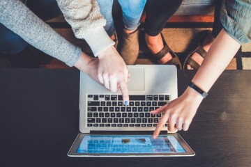 People pointing at a laptop screen