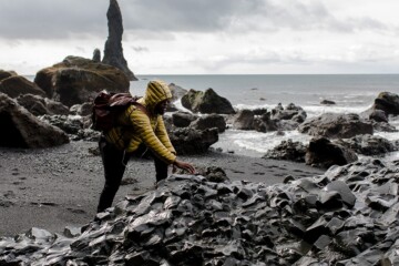 Person climbing rocks on a beach