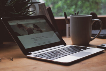 Computer on a desk with a cup of coffee