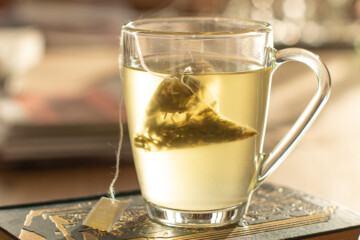 Glass mug of tea on a book