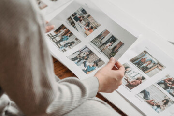 A person in a white shirt flips through a brand guide with photos of their target audience.