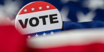 Red, white, and blue VOTE lapel pin.