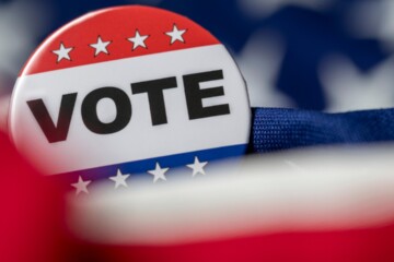 Red, white, and blue VOTE lapel pin.