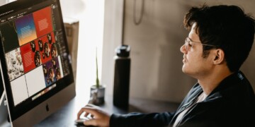 Man sitting at a computer looking at AI generated images.