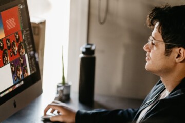 Man sitting at a computer looking at AI generated images.