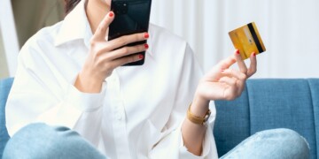 woman holding mobile phone and credit card